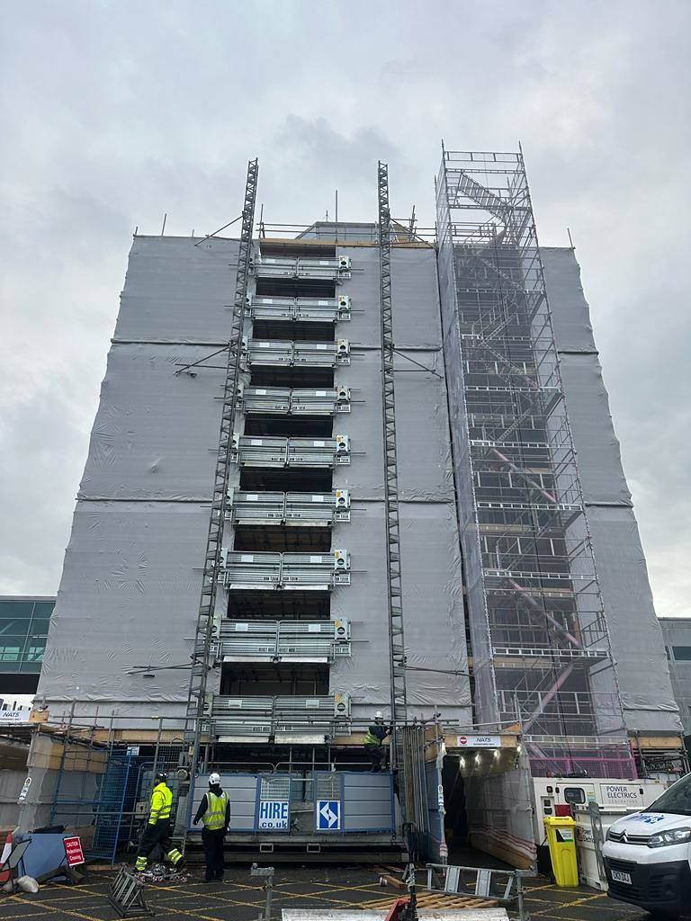 Airport control tower scaffold encapsulated with grey Rhino Shrink Wrap for temporary weather protection during refurbishment
